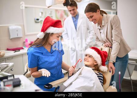 Weibliches Kind am Zahnarzt während der Weihnachtsfeiertage Stockfoto