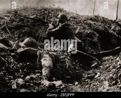 Während der Schlacht um Verdun im Februar 1916 verwendete ein deutscher Soldat die Abdeckung eines beschädigten Grabens neben dem Leichnam eines französischen Soldaten. Stockfoto