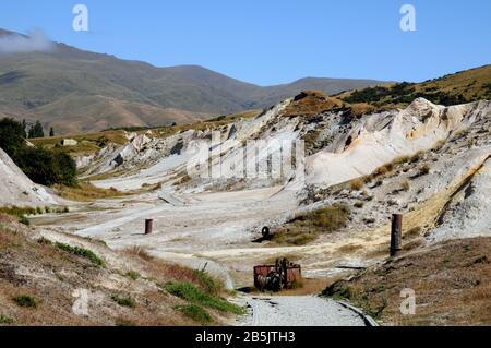 Das Gebiet des Blue Lake in St Bathans in Central Otago, Neuseeland. Der See wurde von Bergleuten gebildet, die durch Felsen schlürfen, um an das Gold zu gelangen. Stockfoto