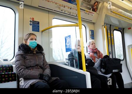 Pendler der Londoner U-Bahn tragen Gesichtsmasken zum Schutz vor Coronavirus Übertragung. Stockfoto