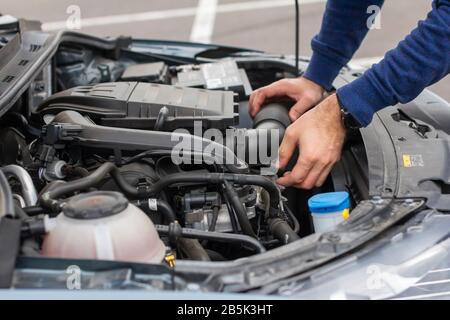 Nahaufnahme des mechanischen Handprüfmotors unter der Haube im zerbrochenen Auto. Reparatur des Fahrzeugkonzepts. Automobilservice Stockfoto