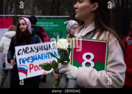 Moskau, Russland. März 2020 TEILNEHMER einer Kundgebung 'MARCH 8 - feiere den Urlaub richtig' für die Solidarität der Frauen und die Rechte der Frauen, Organisiert von der Gruppe weiblicher Aktivisten, um den Internationalen Frauentag im Moskauer Sokolniki Hyde Park zu markieren. Die Demonstranten zeichnen sich durch einen Gesetzesentwurf aus, der Frauen vor häuslicher Gewalt schützt, für Gleichberechtigung, gegen Sexismus, weibliche Objektivierung und politische Unterdrückung. Ein Banner auf dem Hintergrund lautet "Nächster Präsident Russlands". Stockfoto