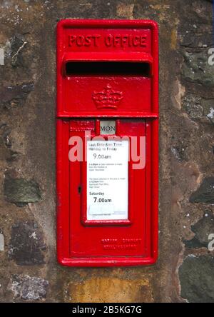 Rot lackierte britische Postbox in einer Wand Stockfoto