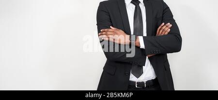 Zugeschnittenes Porträt eines erfolgreichen afrikaners mit Armen über grauem Hintergrund mit Kopierbereich Stockfoto