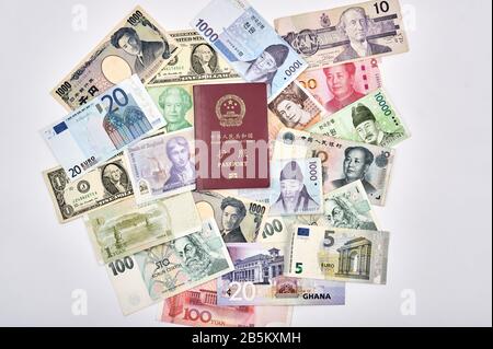 East trifft auf das Reisekonzept der westlichen Welt mit chinesischem Pass und einer Mischung aus westlichen und asiatischen Währungen Stockfoto