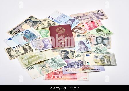 East trifft auf das Reisekonzept der westlichen Welt mit chinesischem Pass und einer Mischung aus westlichen und asiatischen Währungen Stockfoto