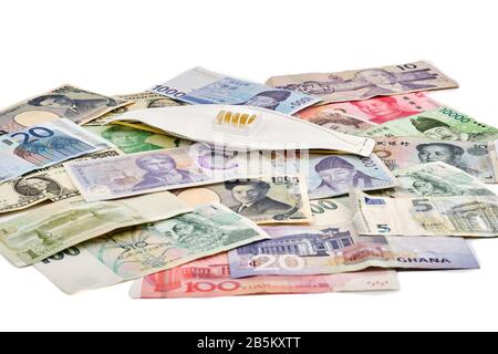 Reisen Sie sicher durch das Weltkonzept mit Corona-Virusmaske und einer Mischung aus westlichen und asiatischen Währungen Stockfoto