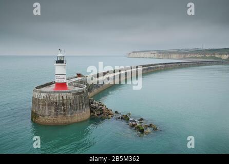 Roter Leuchtturm auf grünem Meer am Newhaven Harbour, Sussex Stockfoto