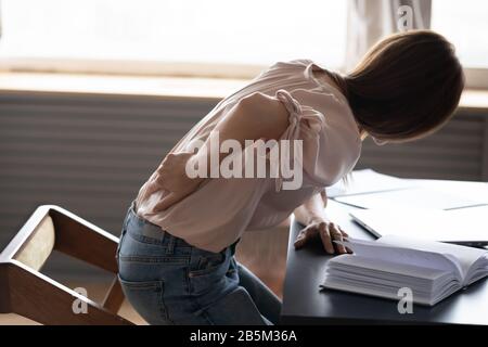 Ungesunde, unzufriedener junge Frau steigt vom Stuhl auf. Stockfoto