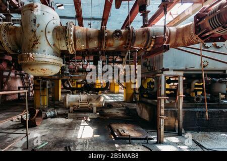 Alte rostige Industrietanks, die durch Rohre verbunden sind, die mit Ventilen in der verlassenen chemischen Fabrik verbunden sind. Stockfoto