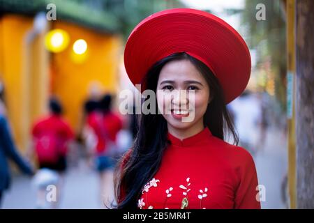 Eine junge Vietnamesin, die ein traditionelles rotes Kleid (Ao Dai) trägt Stockfoto