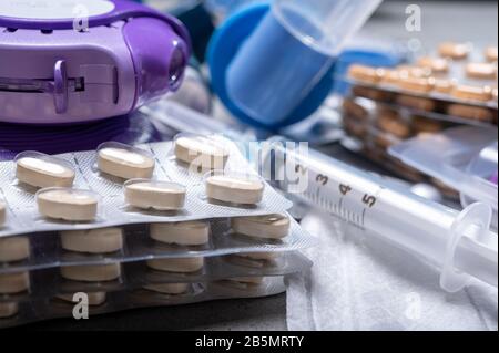 Verschiedene Medikamente für Asthmabedrohungen, Pillen, Inhalatoren, Blutteströhrchen und Spritzen, Krankenhaushintergrund aus nächster Nähe Stockfoto