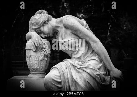 Traurige und weinende Frauenskulptur. Trauernde Expressionsskulptur mit Traurigkeit im weinenden Denken. Schwarzweiß-BW-Fotografie. Stockfoto