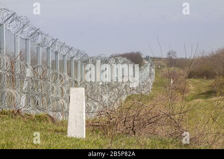 Grenzzaun zwischen Rastina (Serbien) und Bacsszentgyorgy (Ungarn) mit Grenzmarkierung. Dieser Grenzwall wurde 2015 errichtet, um ankommende Flüchtlinge zu stoppen Stockfoto