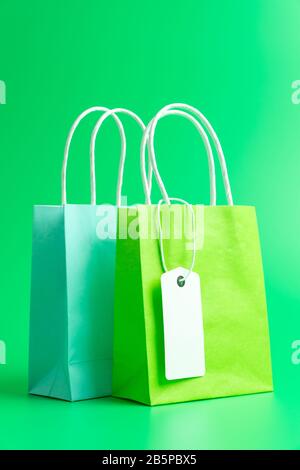 Zwei grüne Einkaufs- oder Geschenkbeutel isoliert auf grünem Hintergrund Stockfoto