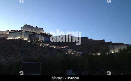 Dämmerung und elektrische Beleuchtung in Gyantse Dzong, einer Festung, die über der gleichnamigen Stadt in Tibet thront Stockfoto