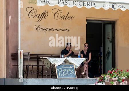 Ein Mann und eine Frau auf der Veranda eines Cafés und einer Bar in Ravello. Solche Orte und Restaurants sind in jedem Dorf und Stadt an der Amalfiküste, Italien Stockfoto