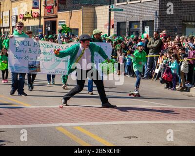 Forest Park, Illinois USA. März 2020. Ein Mann wirft der Menge bei der heutigen Saint Patrick's Day Parade eine Handvoll Süßigkeiten zu. Stockfoto