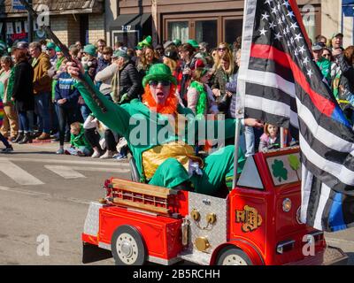 Forest Park, Illinois USA. März 2020. Ein Mann, der als Leprechuan verkleidet ist, fährt während der heutigen Saint Patrick's Day Parade in einem Miniatur-Feuerwehrwagen. Stockfoto