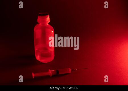 Spritze für Injektion und Medikamente in einem transparenten Behälter auf grauem Hintergrund. Kopierbereich Stockfoto