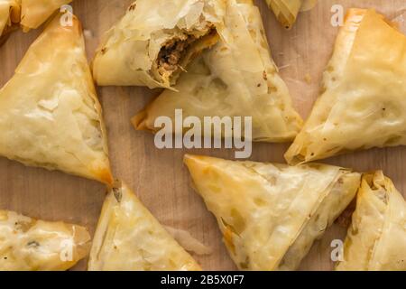 Backofenbackene Phyllo-Gebäck-Samosas mit würzigem Fleisch - Draufsicht Foto von Vorspeisen Snacks auf Holzbrett Stockfoto