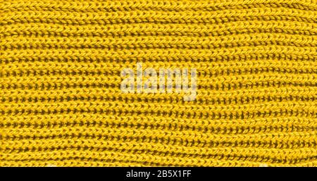 Leuchtend gelber Strickschal aus Wollstoff. Gelbe Untergrundhose aus Textil. Nahaufnahme Stockfoto