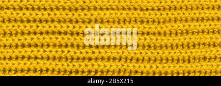 Leuchtend gelber Strickschal aus Wollstoff. Gelbe Untergrundhose aus Textil. Nahaufnahme Stockfoto