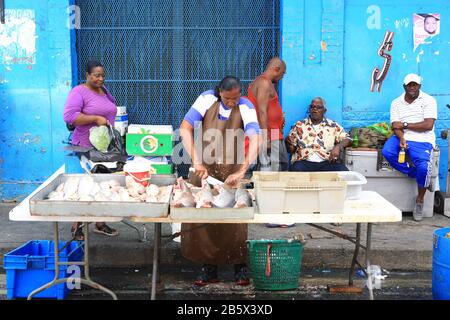 Ein frischer Fischhändler in der George Street bereitet während des Karnevals in Port of Spain, Trinidad, einen Auftrag für einen Kunden vor. Stockfoto