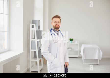 Kinderarzt steht in der weißen Klinik des Krankenhauses. Stockfoto
