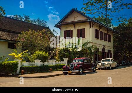 1952 Citroen und 1956 Mercedes-Benz vor dem 3 Nagas Hotel geparkt in Prabangs Altstadt, Laos. Stockfoto