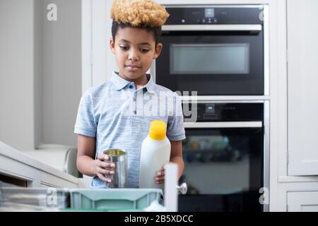 Junge Sortierung Recycling in Küche bin zu Hause Stockfoto