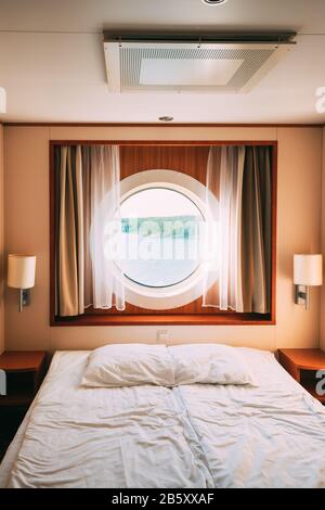 Schiffskabine Mit Bett Und Fenster Mit Blick Auf Das Meer. Luxuskabine Mit Fährschiff Oder Kreuzfahrt-Liner Stockfoto