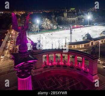 Budapest, Ungarn - Abendansicht des einzigartigen violett- und pinkfarbenen Heldenplatzes mit Eis-Rink im Stadtpark und Schloss Vajdahunyad im Hintergrund Stockfoto