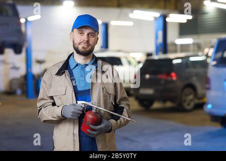Horizontaler Bund hoch Hochformat des reifen Kaukasier Auto-Mechanikers mit Gasbrenner Blick auf Kamera, Kopierraum Stockfoto