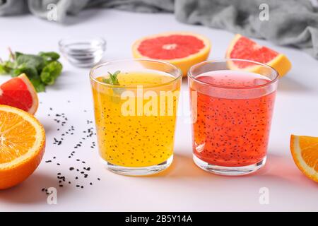 Trendiger tropischer Orangen- und Grapefruitsaft mit Basilikumsamen oder Faloodsamen oder Tukmarie aus Glas auf weißem Grund Stockfoto