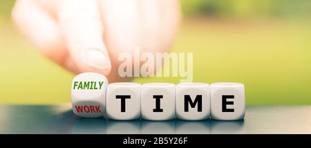 Hand dreht Würfel und ändert den Ausdruck "Arbeitszeit" in "Familienzeit". Stockfoto