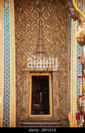 13. Mai 2010 Bangkok, Thailand - Wunderschönes historisches Golden-geschnitztes thailändisches Fenster und Wand des Bangkok Grand Palace Gebäudes - Wat Phra Kaews Stockfoto