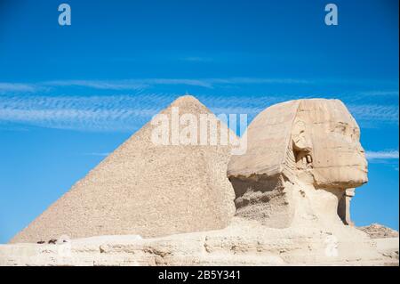 Helle, sonnige Sicht auf das zerfallende Profil der Großen Sphinx von Gizeh, die vor der Großen Pyramide auf dem Giza-Plateau in Ägypten steht Stockfoto