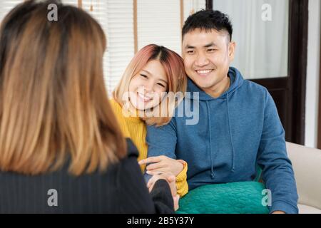 Asiatisches glückliches Paar erhält Schlüssel und Handschlag mit Realtor-Agent mit lächelndem Gesicht in neuem Haus.Kauf neuer Hausimmobilien Stockfoto