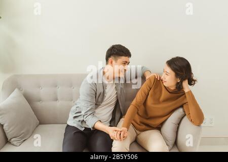Frau ist traurig und depressiv, ihr Mann tröstet sie. Stockfoto