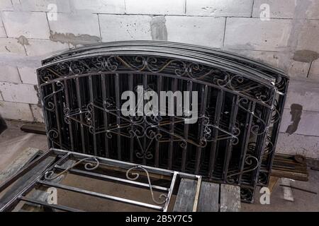 Teil eines schwarzen Metallzauns aus Stahlstäben mit geschmiedetem Stahl Stockfoto