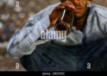 Hände des depressiven jungen Obdachlosen Afrikaners, der Bier trinkt Stockfoto