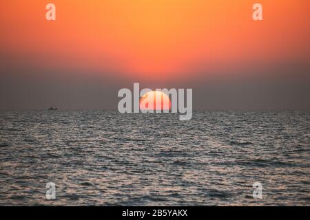 Sonnenuntergang über dem Meer bei Sonnenuntergang. Natürlichen Sonnenaufgang Himmel, warmen Farben über das Meer. Big Sun über Meer Stockfoto