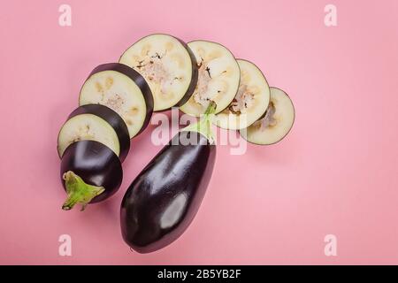 In der Nähe reifer violetter Auberginer auf pinkfarbenem Hintergrund. Draufsicht. Kopierbereich Stockfoto