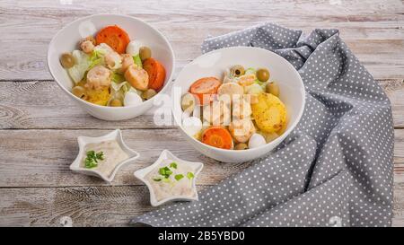 Fisch und Meeresfrüchte - Banner. Köstlicher Salat mit Jakobsmuschel, Gemüse, Mozzarella-Käse und Oliven auf einem rustikalen Holztisch Stockfoto