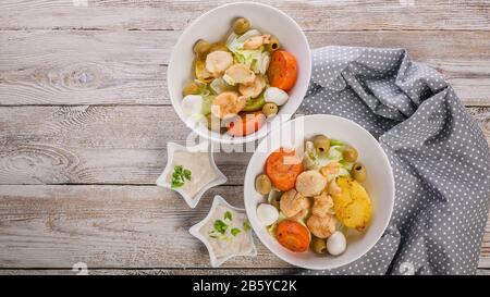 Fisch und Meeresfrüchte - Banner. Köstlicher Salat mit Jakobsmuschel, Gemüse, Mozzarella-Käse und Oliven auf einem rustikalen Holztisch. Draufsicht. Kopierbereich Stockfoto