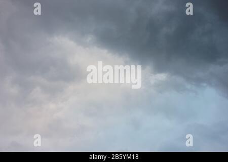 Verschwommener dramatischer Himmelshintergrund. Aufregende dunkle stürmische Wolken vor Regen Stockfoto