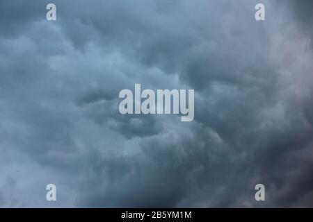 Verschwommener dramatischer Himmelshintergrund. Aufregende dunkle stürmische Wolken vor Regen Stockfoto