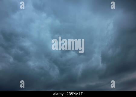 Verschwommener dramatischer Himmelshintergrund. Aufregende dunkle stürmische Wolken vor Regen Stockfoto