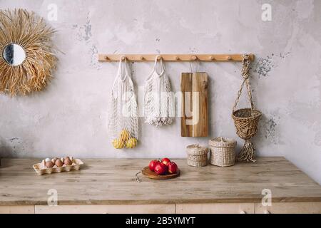 Küche im rustikalen Stil mit Möbeln in grauer Farbe und Holztisch. Gesunde Ernährung. Mit Äpfeln, Eiern. Stockfoto